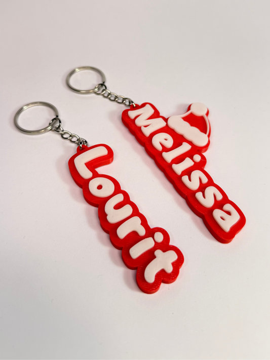 Red keychains with 'Melissa Lourit' text on a white background